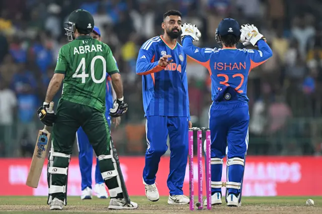 India's Varun Chakravarthy (C) celebrates with wicketkeeper Ishan Kishan after taking the wicket of Pakistan's Abrar Ahmed during the 2026 ICC Men's T20 Cricket World Cup group stage match between India and Pakistan at the R Premadasa Stadium