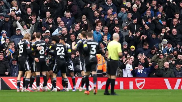 Fans of Leeds United celebrate after Lukas Nmecha