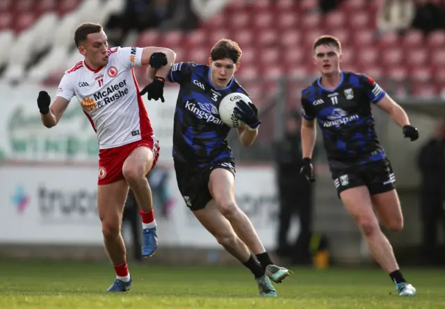 Cavan's Paddy Meade is tackled by Tyrone's Conn Kilpatrick