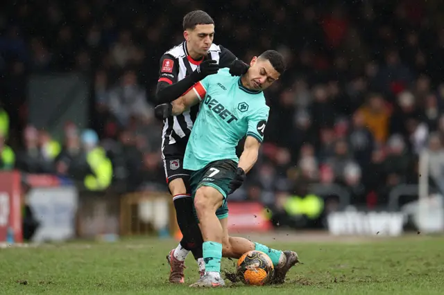 Grimsby's Irish striker #09 Jaze Kabia (L) vies with Wolverhampton Wanderers' Brazilian defender #07 Andre (R) during the English FA Cup fourth round football match between Grimsby Town and Wolverhampton Wanderers at Blundell Park in Grimsby, north-east England on February 15, 2026.