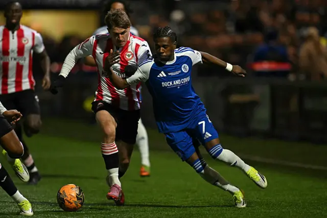 Brentford's Ukrainian midfielder #18 Yehor Yarmolyuk (C) fouls Macclesfield's English striker #07 Isaac Buckley-Ricketts (R) during the English FA Cup fourth round football match between Macclesfield Town and Brentford at Leasing.com Stadium, Moss Rose in Macclesfield, northern England on February 16, 2026.