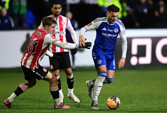 Macclesfield's Paul Dawson competes with Brentford's Yehor Yarmolyuk during the Emirates FA Cup Fourth Round match between Macclesfield and Brentford on February 16, 2026 in Macclesfield, England.