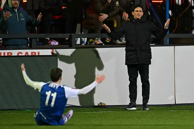 Brentford's Irish head coach Keith Andrews (R) and Macclesfield's English striker #11 Luke Duffy (L) do some gesturing during the English FA Cup fourth round football match between Macclesfield Town and Brentford at Leasing.com Stadium, Moss Rose in Macclesfield, northern England on February 16, 2026.