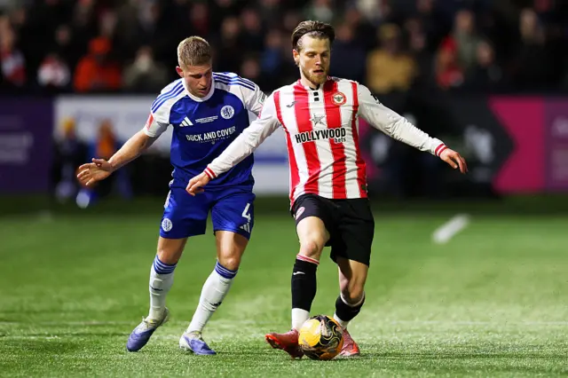Mathias Jensen of Brentford controls the ball whilst under pressure from Lewis Fensome of Macclesfield during the Emirates FA Cup Fourth Round match between Macclesfield and Brentford at Moss Rose Ground on February 16, 2026 in Macclesfield, England.