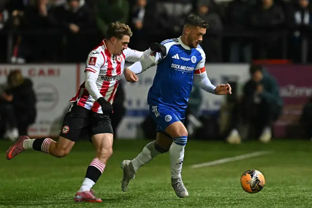 Brentford's Ukrainian midfielder #18 Yehor Yarmolyuk (L) vies with Macclesfield's English midfielder #06 Paul Dawson (R) during the English FA Cup fourth round football match between Macclesfield Town and Brentford at Leasing.com Stadium, Moss Rose in Macclesfield, northern England on February 16, 2026.