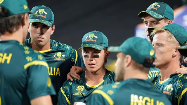 Adam Zampa of Australia looks on in the team huddle before they field