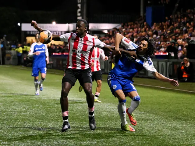 Brentford's Michael Kayode in action with Macclesfield Town's D'Mani Bughail-Mellor