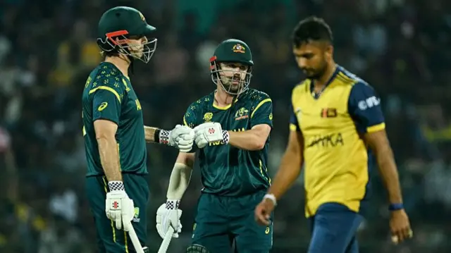 Australia's captain Mitchell Marsh (L) and Travis Head (C) bump their fists