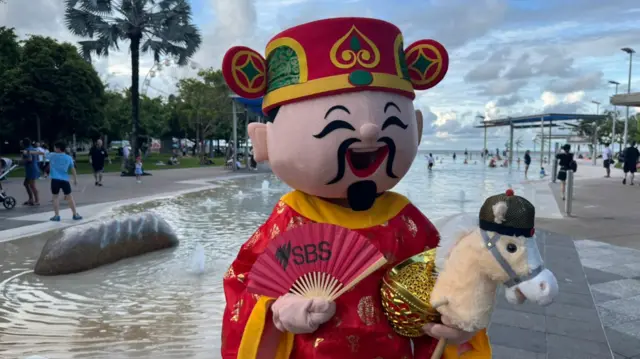 A mascot holds a stuffed horse in Cairns, Australia