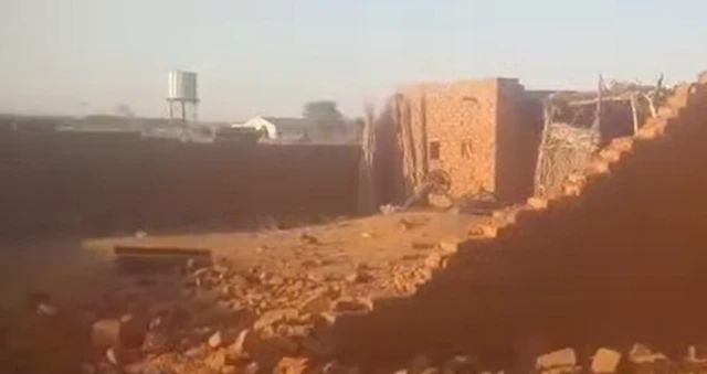 A white water tower in the background and brick buildings in the foreground are seen in this grab from the video