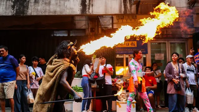 Man breathing fire at a parade in Manila Chinatown