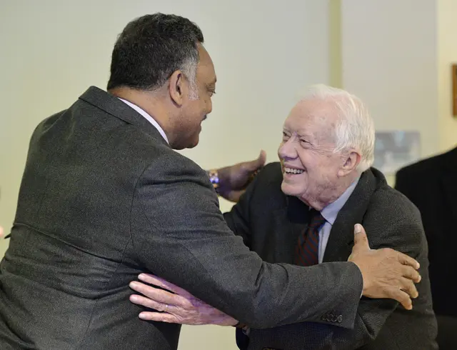 Former US President Jimmy Carter hugs Jackson at a signing for his book on March 27, 2014 in Chicago, Illinois.
