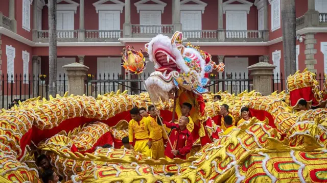 A giant golden dragon surrounding Lunar New Year dancers