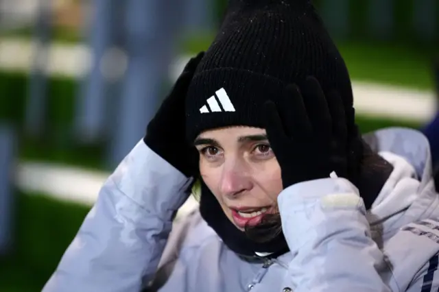 Slegers puts her hands to her head on the bench