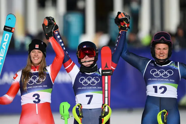 Mikaela Shiffrin of Team United States reacts after winning gold alongside Camille Rast and Anna Swenn Larsson