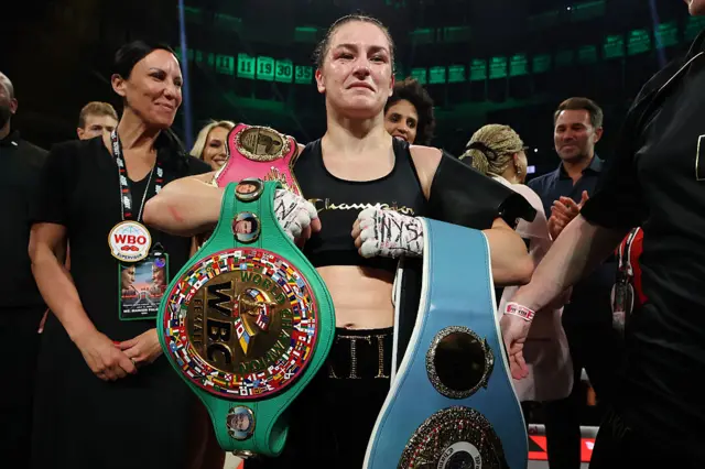 Katie Taylor holds her light-welterweight world titles across her arms