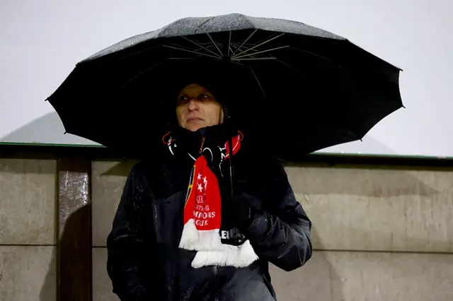 Fan stands with an umbrella at Meadow Park