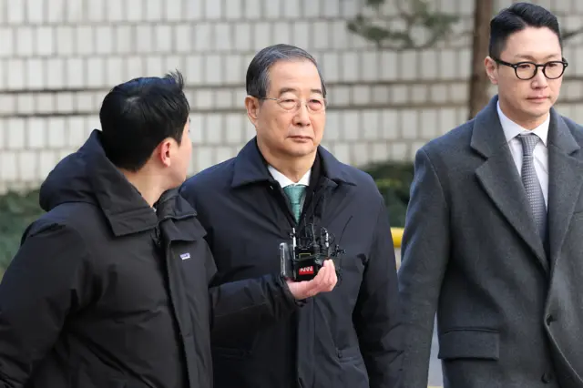 Former South Korean Prime Minister Han Duck Soo walking out of courtroom
