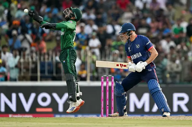 Pakistan's wicketkeeper Usman Khan (L) celebrates after taking a catch to dismiss Namibia's captain Gerhard Erasmus