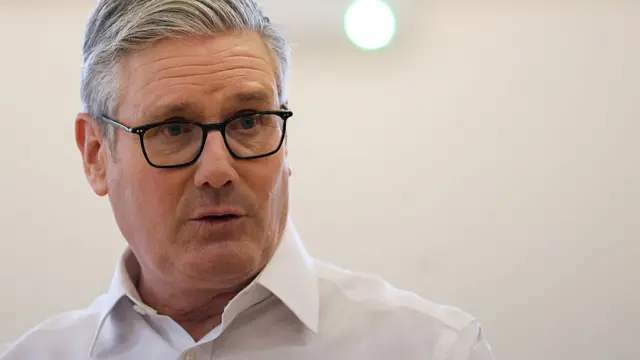 Close up of Starmer in white shirt and black glasses