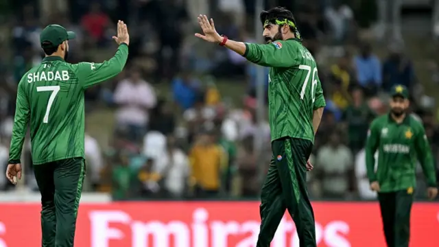 Usman Tariq (C) celebrates with Shadab Khan (L)