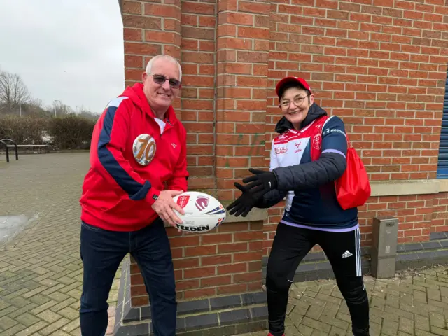 Two people holding the match ball