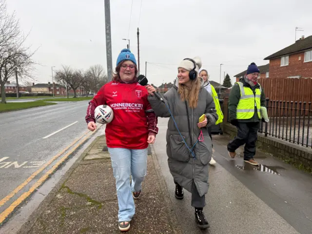 Maddie carrying the relay ball while being interviews by the BBC's Amy Thompson