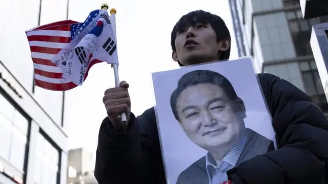 A man carries a photo of Yoon Suk Yeong