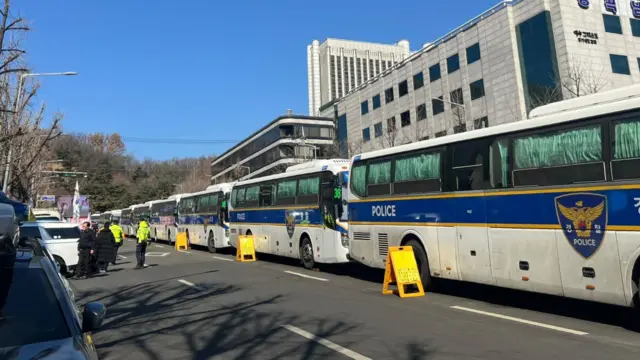 A line of police buses parked along a road outside a South Korea court where Yoon Suk Yeol will receive his verdict