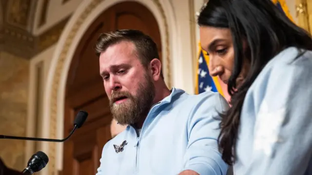 An emotional Sky Roberts speaks into a microphone with Amanda Roberts by his side.
