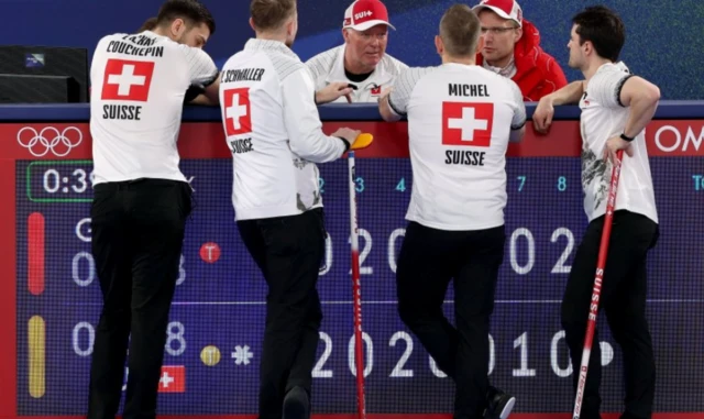 Swiss curlers talk with their coach Havard Vad Peterson