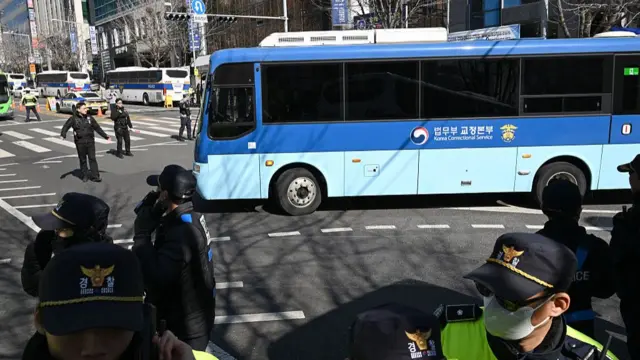 A blue bus driving on a road