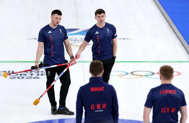 Hammy McMillan and Grant Hardie of Team Great Britain discuss tactics with teammates Bobby Lammie and Bruce Mouat