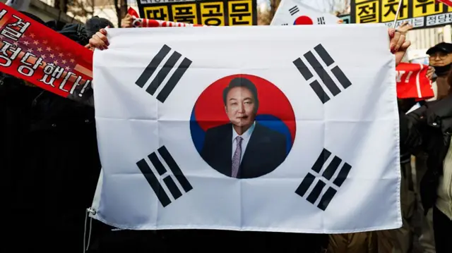 A South Korean flag with Yoon's face printed at its centre