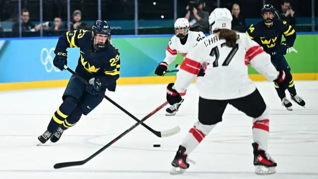 Thea Johansson fights for the puck with Lara Christen