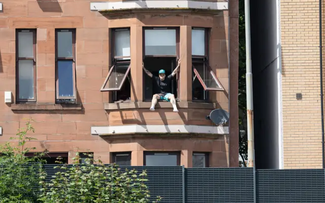 A fan watches from a window