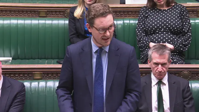 Darren Jones wears a blue suit and blue tie as he addresses the Commons