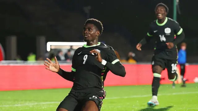 Mohamed Toure sliding on his knees to celebrate scoring for Australia against New Zealand