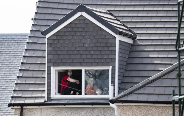 A fan watches from a window