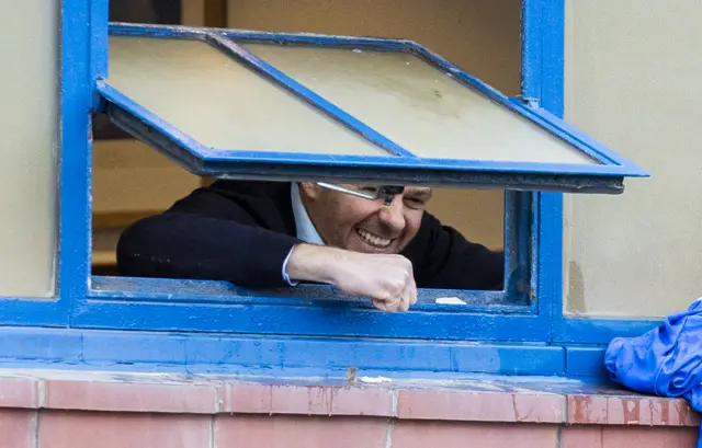Steven Gerrard celebrates out a window