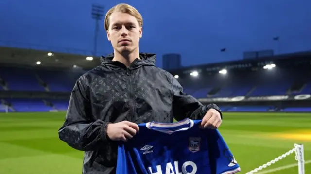 Frankie Runham holding up an Ipswich shirt