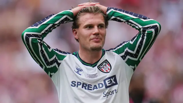Leo Hjelde smiling with his hands on his head after Sunderland's play-off final win over Sheffield United