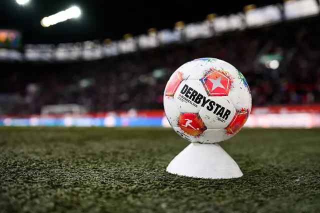 The derbystar match ball sits on a cone on the sideline during the Bundesliga