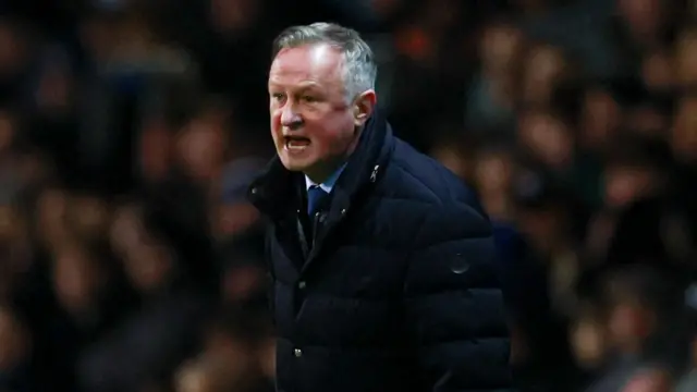 Blackburn boss Michael O'Neill, wearing a dark coat, shouts on the sidelines
