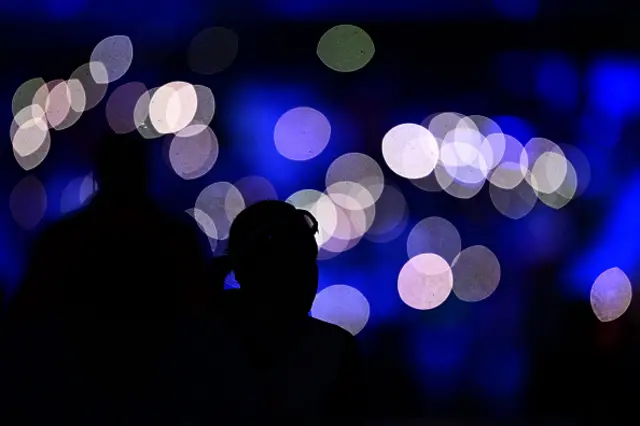 A spectator watches a light show during a break at the speed skating