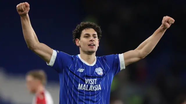 Yousef Salech celebrating scoring a goal for Cardiff with his arms raised above his head