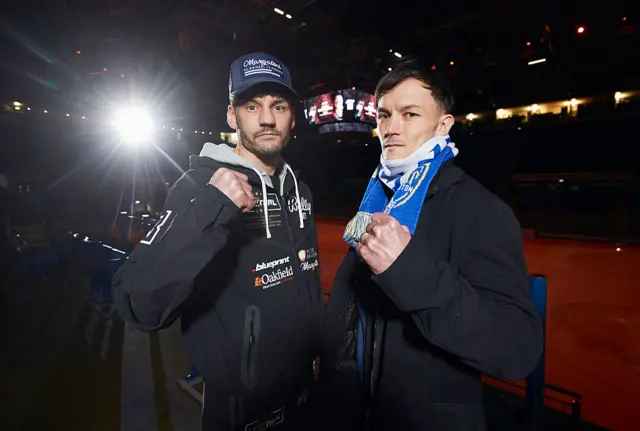 Leigh Wood and Josh Warrington stand side-by-side and hold up a fist