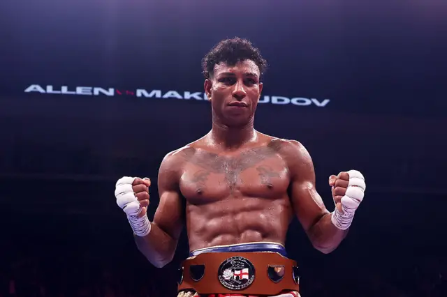 Bilal Fawaz holds up his fists and has the English light-middleweight title around his waist