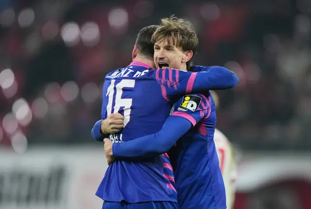 Stefan Posch of 1. FSV Mainz 05 celebrates victory with teammate Stefan Bell following the Bundesliga match between RB Leipzig