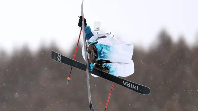 Skier in action with his phone mid air